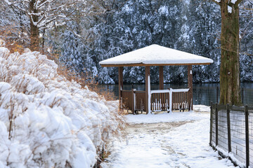 雪に包まれたぎふワールドローズガーデンの東屋と池の冬景色