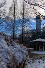 雪に包まれたぎふワールドローズガーデンの東屋と池の冬景色