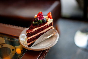 A beautiful blueberry and strawberry cake topped with lemonade, served on a plate, with a cafe as the backdrop.