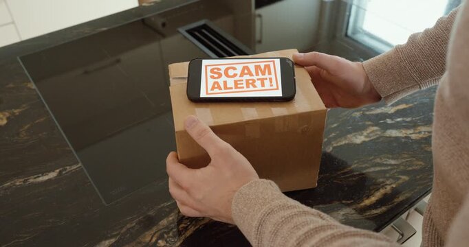 Hands cautiously examine a delivered cardboard parcel on a kitchen counter while a device displays &ldquo;SCAM ALERT.&rdquo; Ideal for concepts like delivery fraud, fake shipments, online shopping scams, consumer