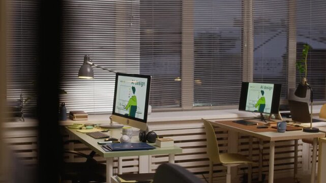 No people shot of contemporary office interior with multiple desks and computers displaying AI design graphics, evening light through blinds and creative professional environment