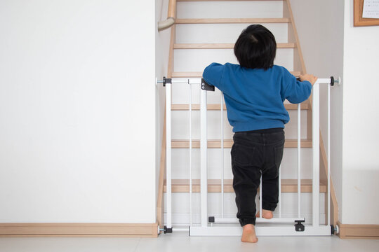 階段前のベビーゲートと立つ幼児