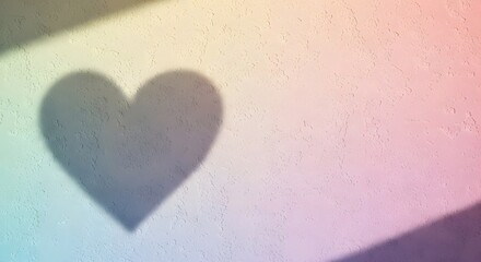 A heart-shaped shadow cast on a surface with a colorful gradient background from an unseen light source