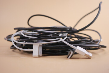 Cables and chargers tangled together on a flat surface
