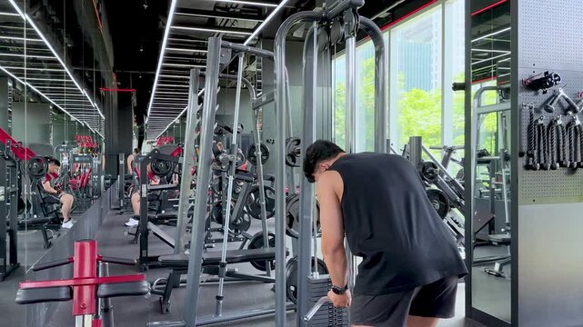 Man Performing Triceps Pushdown Exercise in Modern Gym Setting