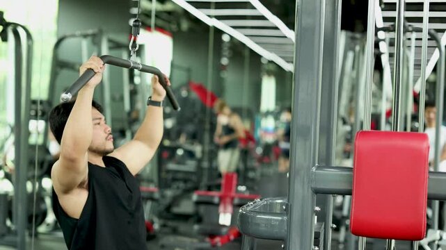 Man Performing Lat Pulldown Exercise in Bangkok Gym