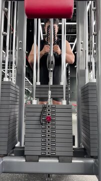 Man Performing Tricep Pushdowns on Gym Machine