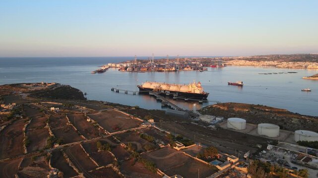 Aerial view of Marsaxlokk Harbor in Malta, showing an industrial port with docked ships