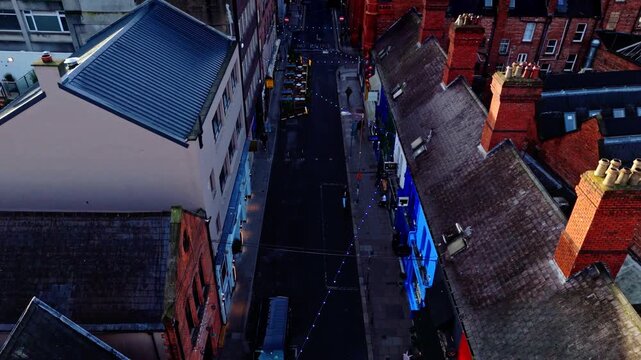 aerial cinematic drone shot going down the capital of Ireland, Dublin's famous Drury street. With bustling roads and streets filled with tourists and locals alike with seagulls flying past at sunrise