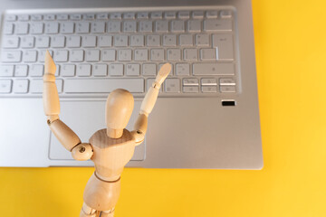 Wooden mannequin working on a laptop