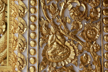 Majestic ornate gold carving shows intricate floral detail. This beautiful traditional Thai pattern from an ancient temple wall creates spiritual and artistic background