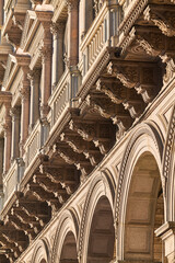 Close-up of classical architectural stone arches and decorative carvings on a Milanese building