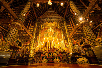 Obraz premium Chiang Mai, Thailand - January,08, 2026:Golden Shrine of Tranquility: The interior of a magnificent temple shimmers with ornate golden details, a large statue of buddha sits as the focal point