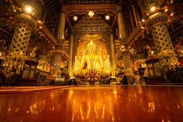 Obraz premium Chiang Mai, Thailand - January,08, 2026:Golden Shrine of Tranquility: The interior of a magnificent temple shimmers with ornate golden details, a large statue of buddha sits as the focal point