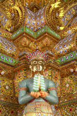 Fototapeta premium Spiritual golden statue with intricate traditional Thai art and architecture detail. Serene Asian deity sculpture reflecting ancient culture, religion, and faith in Thailand
