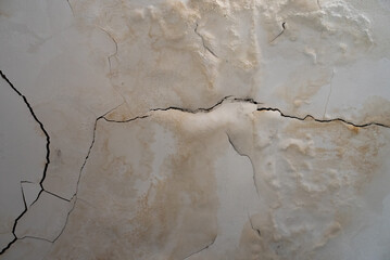 Cracked and Peeling White Wall with Water Damage and Mold Stains