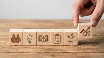 Sequence of six wooden cubes displaying icons for teamwork, ideas, knowledge, planning, growth, and business development results.