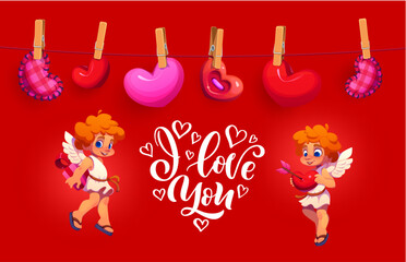 Fototapeta premium Happy Valentine day greeting card featuring two cute playful cupids with wings, surrounded by heart shaped plush decorations hanging on a clothesline, with a white I love you script on red background