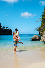 Obraz premium Couple enjoys a romantic moment at Playa Lagun beach in Curacao under a bright blue sky