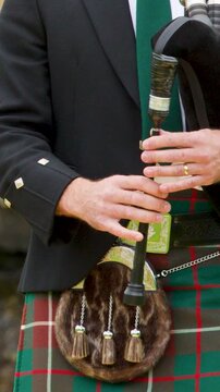 Close-Up of Hands Playing Bagpipes in Traditional Scottish Highland Dress