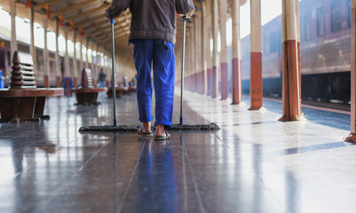 Fototapeta premium Worker diligently cleaning train station platform floor