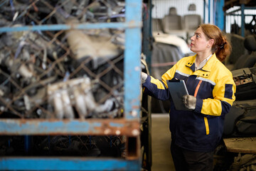 Worker examines metallic scrap inside a factory