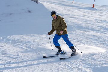 A skier in full gear skillfully descends a snow-covered mountain slope under a bright sun. Perfect for showcasing winter sports and the excitement of skiing in a scenic environment.