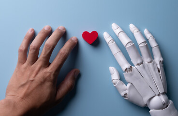 Human and Robotic Hands Reaching for Red Heart on Blue Background