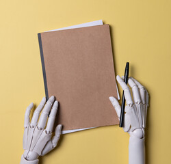 Robot Hands Holding Brown Notebook and Black Marker on Yellow Background