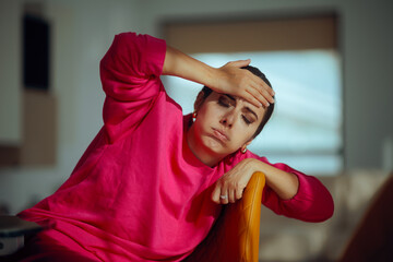 Tired Exasperated Woman Sitting on Chair a with  Hand on the Forehead. Mom struggles with everyday...