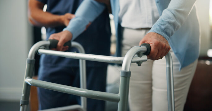 Person, hands and senior patient with walker for assisted living, balance or mobility in home. Closeup, caregiver or nurse helping elderly with walking aid for steps, physiotherapy or muscle recovery