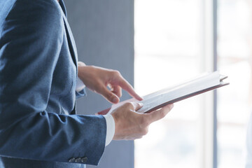 紙資料を指差しチェックする男性ビジネスマン