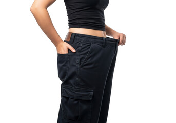 Woman showing weight loss success by wearing very large pants, isolated on transparent background
