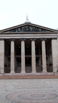 centered symmetrical ground level oslo norway university domus ionic columns reliefs statues stone plaza define scene view of academica 
