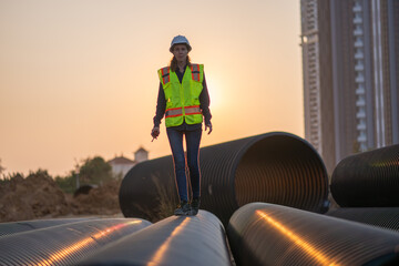 Engineer working Industrial pipeline system used for water supply or electrical cable protection large cylindrical pipes arranged in infrastructure underground utilities and public infrastructure.