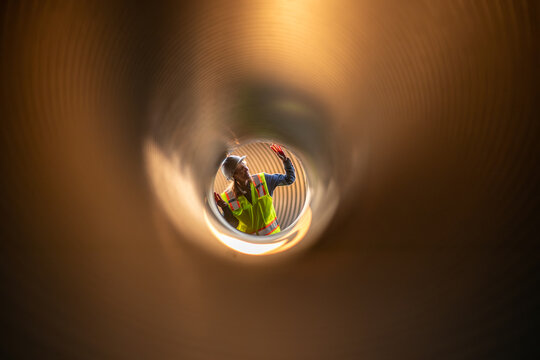 Engineer working Industrial pipeline system used for water supply or electrical cable protection large cylindrical pipes arranged in infrastructure underground utilities and public infrastructure.