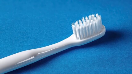 Close Up of White Toothbrush with Soft Bristles on Textured Blue Surface Healthcare and Hygiene Product Still Life for Dental Care and Oral Health Concept