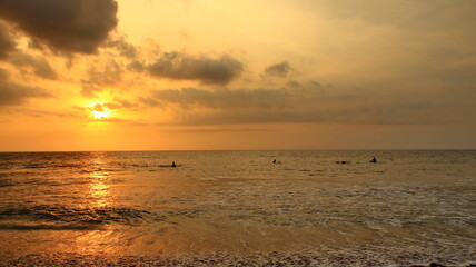 Beautiful sunset orange sky over the ocean horizon with waves reflecting light on the beach nature landscape at dusk