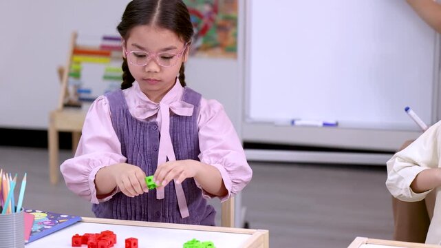 Elementary School Girl Counting Colorful Math Manipulative Blocks