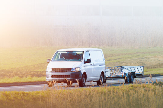 Family car pulling a silver utility trailer