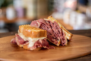 Fototapeta premium A corned beef sandwich on a wooden board in a modern restaurant