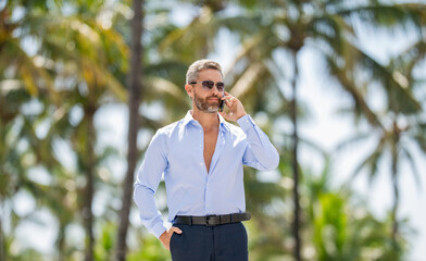 Businessman using phone. Man phone conversation. Hispanic business man with smartphone. Business communication. Man reply phone call. Casual businessman talking on phone outdoor