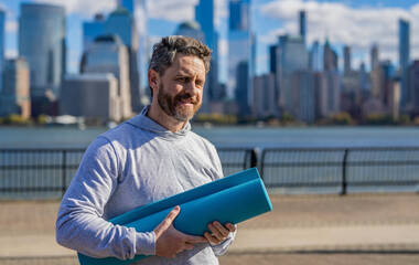 Yoga coach. Sport man ready for workout. Healthy lifestyle. Fitness and sport. Yoga mat training. Sportsman in New York. Man in sportswear with fitness mat in Manhattan. Fit your body. Exercise mat