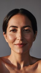 Close-up of a middle-aged Arab woman's face without a hijab on an isolated gray background.