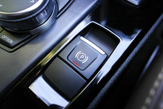Electronic Parking Brake, A close-up of the electronic parking brake EPB button with the P symbol in a luxury vehicle console for secure stationary parking.