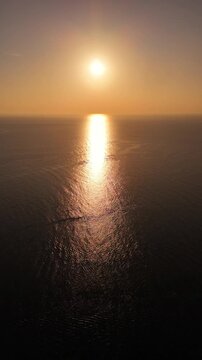 Cinematic aerial drone view of a vivid orange tropical sunset over the Andaman Sea near Phuket, Thailand. Dramatic sky and glowing ocean create a powerful island atmosphere and travel-inspired seascap