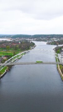 high altitude full steel arch bridge glomma river tracks depots parks neighborhoods cityscape unfold fredrikstad norway reveals drone view urban infrastructure rail yards 