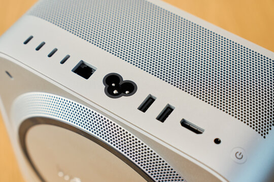 Close-up of back panel of compact desktop computer with power input, USB ports, network connector and ventilation grille