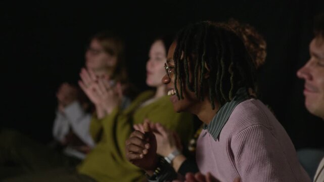 Diverse audience applauding during creative public event, showing appreciation and positive reaction to speaker in modern professional setting