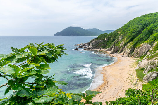 Beach on Sea of Japan coast at Primorsky krai (Primorye), with yellow sand and beautiful landscape popular among tourists.
